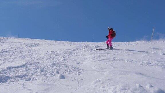一个女人在陡峭的山坡上滑雪慢慢地从山上滚下来