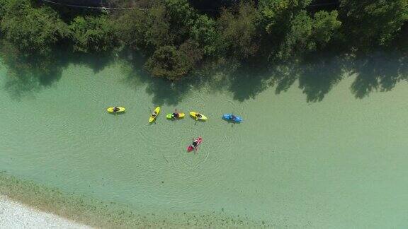 空中俯瞰:一群皮划艇选手滑下清澈的翡翠溪流