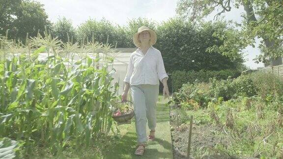 一位年长的白人妇女走过她的花园