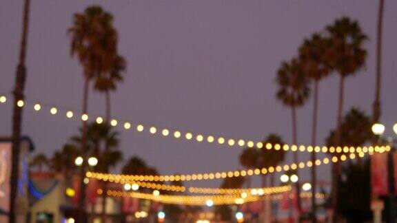 装饰夺目的花环灯棕榈树的剪影傍晚的天空模糊的背景在加利福尼亚用灯装饰的街道节日灯饰海滩派对热带度假概念