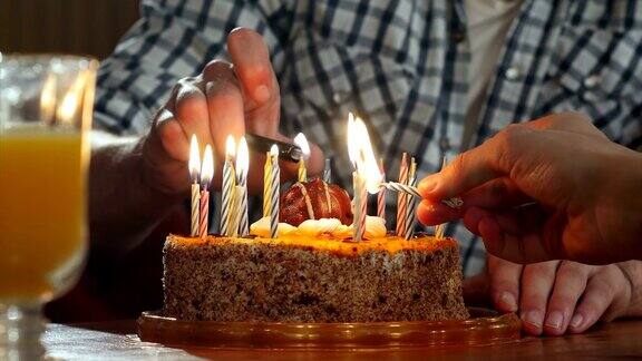 两只手在生日蛋糕上点燃蜡烛