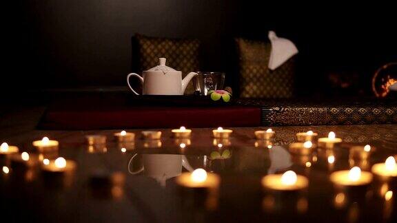 炽热的心蜡烛排成心形心形的蜡烛背景上有一个茶壶Slowmotion拍摄