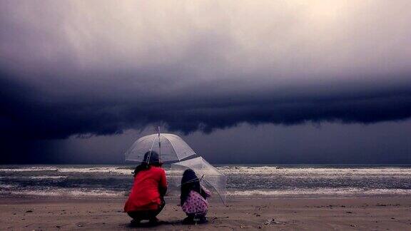 4k:母亲和女儿看起来像海面上的大风黑色风暴架云