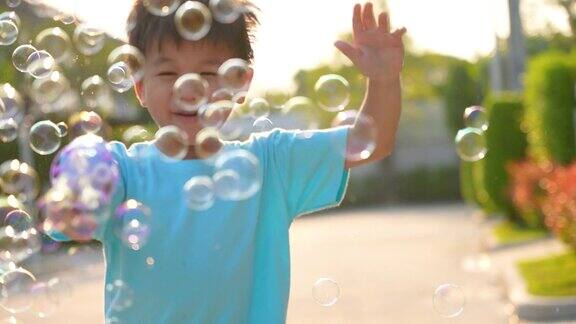 亚洲小孩在公园玩泡泡幸福和夏日