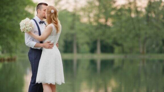 新婚夫妇在湖边接吻