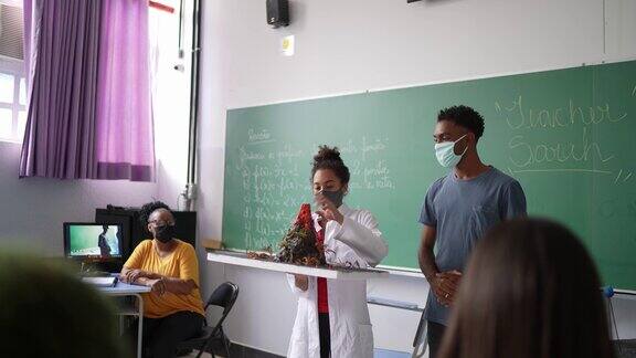 学生在教室里用口罩做关于火山的演讲