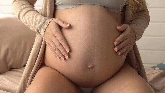 温柔的女人温柔地抚摸着她的肚子美丽的孕妇特写
