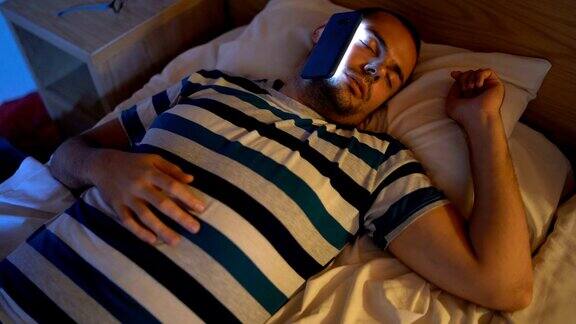 一个脸贴着手机睡着的男人