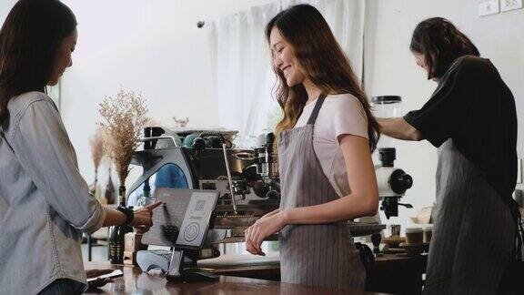 亚洲顾客通过平板电脑点咖啡在咖啡厅柜台柜台用平板电脑进行非接触式手机支付小型企业开始客户服务理念