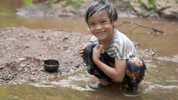 亚洲小男孩在小溪里玩水