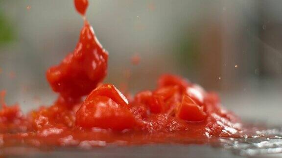 切碎的圣女果落入煮熟的番茄酱中放在黑色的盘子里
