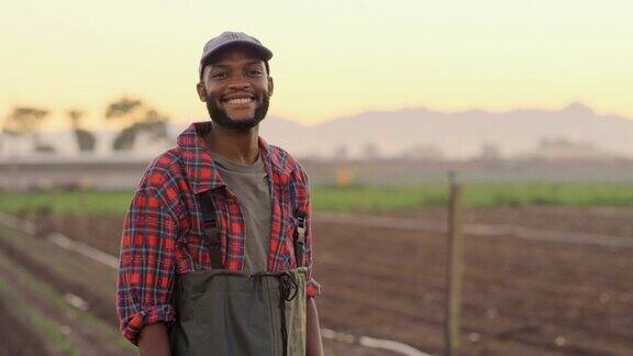 年轻的非洲裔美国男性农民站在农场微笑早上站在田野里微笑的男人