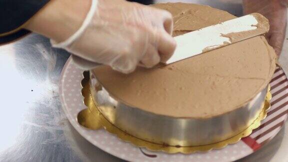 糕点师站在蛋糕架上在蛋糕上洒奶油