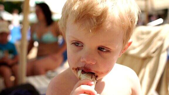小男孩在游泳池附近吃巧克力冰淇淋