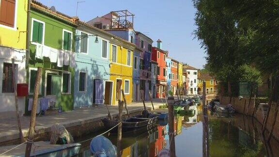 漫步在一条狭窄平静的水道上穿过威尼斯生动的街道