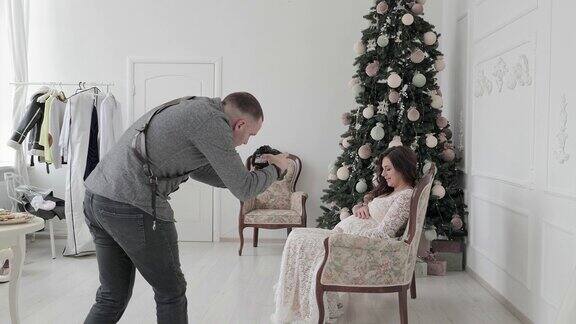专业摄影师在摄影棚为怀孕的模特拍照