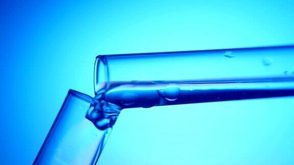 在医学实验室里清洁的液体从一个管子倒进另一个管子