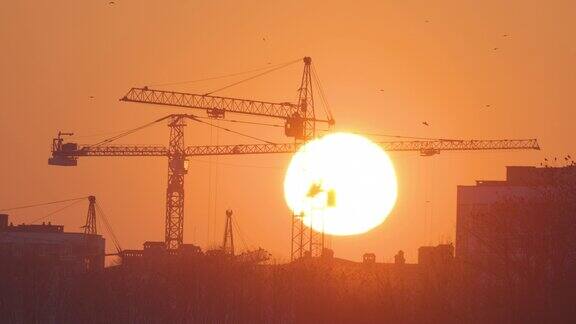 夕阳下高楼公寓建筑工地塔吊的黑色剪影房地产开发