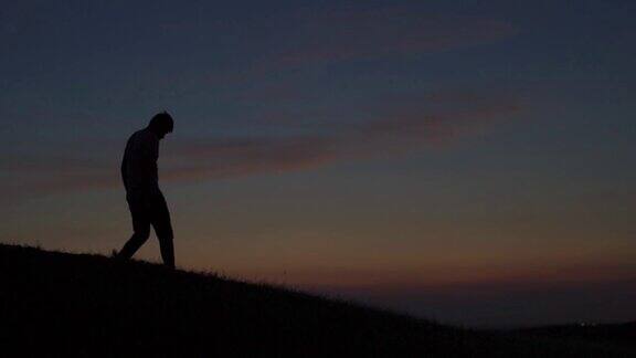 一个印度人在夕阳下下山的剪影日落时徒步者从山顶下来徒步者到达山顶后返回旅游的背景