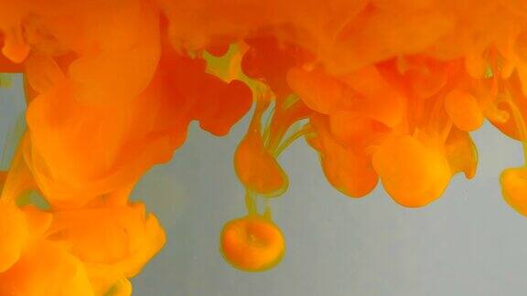 墨水在水里橙色闪光涂料与水反应形成抽象的云可以用作过渡添加到现代垃圾项目艺术背景任何创造性扭曲