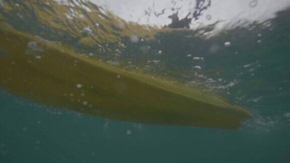 分割镜头与水下视角一个年轻女子在海里划着皮划艇