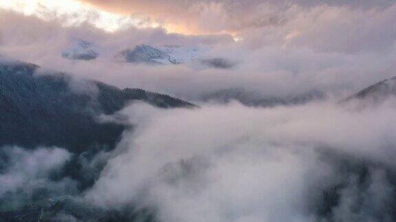 日落时分新下了雪的群山中弥漫着雾气