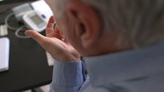 冠状病毒隔离期间老人一边吃药一边与医生视频通话
