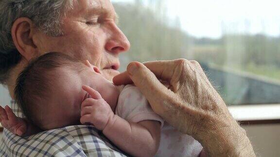 爷爷抱着熟睡的刚出生的孙女