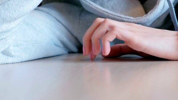 特写女人的手紧张地用手指敲着桌子