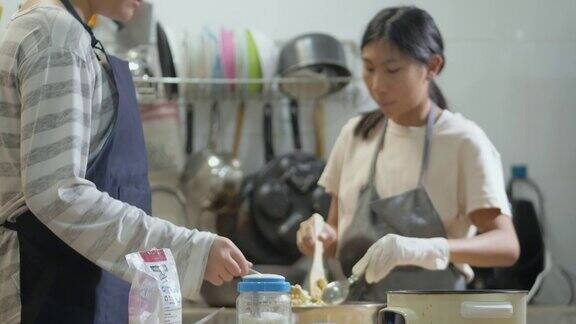 亚洲孩子穿着围裙在厨房里一起做焦糖爆米花周末生活理念