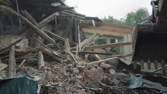被毁房屋的废墟和瓦砾、木石废弃物、被毁房屋和挖掘机铲斗