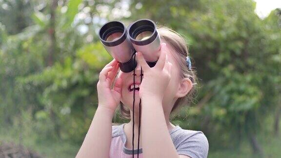 SLOMO可爱快乐的儿童女孩使用望远镜
