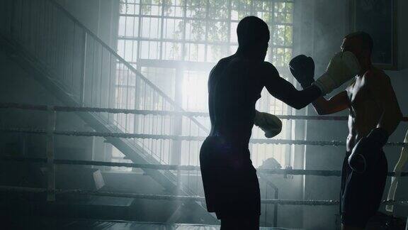 电影慢镜头近距离拍摄的两个专业的年轻肌肉裸男拳击手正在拳击场战斗