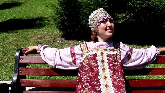女孩坐在长椅上穿着俄罗斯民族服装