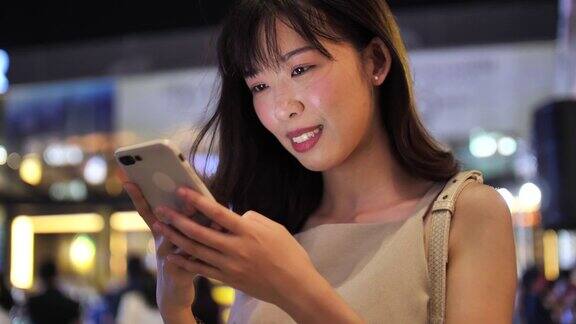 日本妇女在晚上使用手机