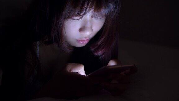 女人晚上在床上使用手机