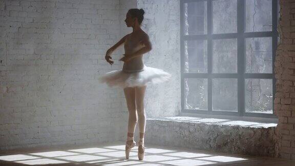 专业芭蕾舞演员在有大窗户的房间里表演脚尖旋转