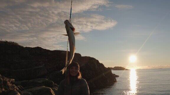 挪威户外:妇女在海里用钓竿纺纱捕鱼
