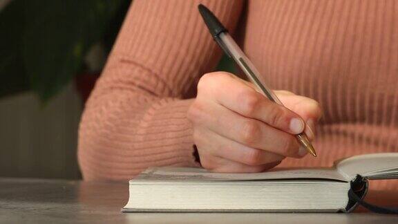 女人的手打开笔记本和书写