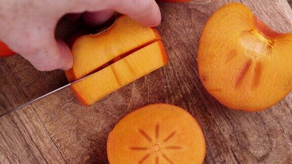 新鲜成熟的柿子在砧板上切成小块