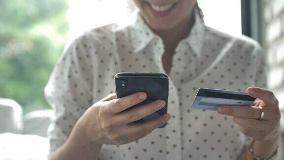 亚洲女人在智能手机上购物和使用信用卡