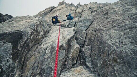 专业登山者攀登欧洲阿尔卑斯山的陡峭山峰使用绳子查找