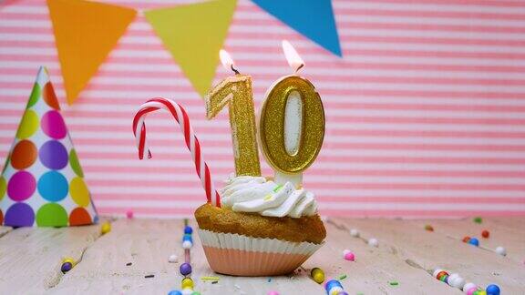 祝一个十岁的孩子生日快乐一个美丽的视频背景一个十岁的生日快乐在粉红色的背景上一个奶油纸杯蛋糕和一支火蜡烛
