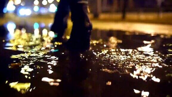 近距离的慢动作拍摄的女人的腿进入泥泞的水坑使水花
