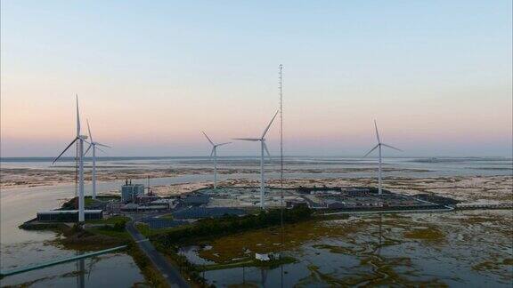 可持续能源用于环境保护美国新泽西州大西洋城附近的一个由风力涡轮机和太阳能板供电的污水处理厂航拍视频与后退摄像机运动