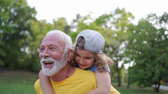 顽皮的孙子背着活泼健康的祖父两人都在运动间隙玩耍