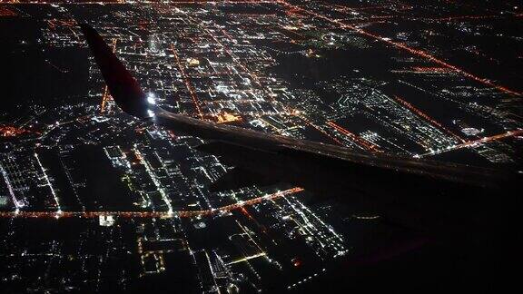 夜间在城市上空飞行的飞机机翼