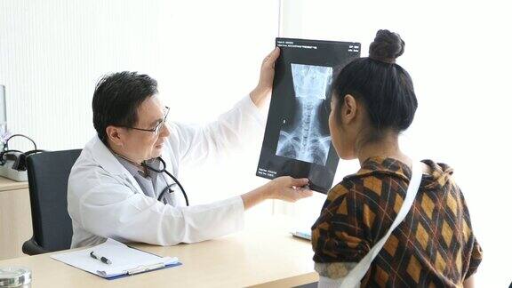 在医院的办公室里医生正在向一位女病人解释脑部x光的结果(4k的分辨率)