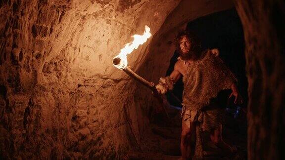 原始穴居人披着兽皮在夜里探索洞穴拿着火把在夜里看墙上的画尼安德特人寻找安全过夜的地方