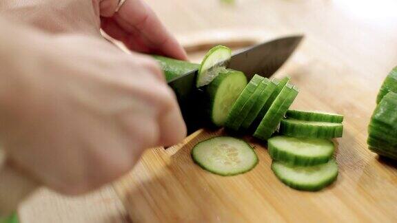 用锋利的菜刀将新鲜的黄瓜切成薄片放在砧板上